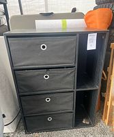 Full view of black storage unit with drawers and shelves