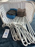 Hamper on side showing interior with washcloths and hangers