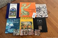 All six books and five coasters laid out on floor, covers and artwork visible