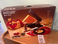 Front of box showing TTM Party raclette apparatus and accessories