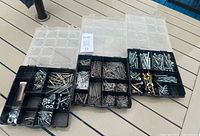 All three divided plastic organizers open showing assorted fasteners