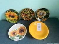 All five sunflower-themed plates displayed