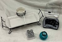 Photo showing rectangular ceramic tray with round dip bowl in wrought iron holder, metal shaker jars, blue aqua votive ball, and black wine opener set.