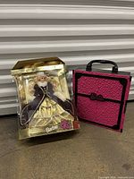 Barbie Happy Holidays 1996 doll in gold packaging and pink Barbie wardrobe case with black handle