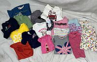 Photo showing 18 assorted pieces of vintage children's clothing including shirts, tops, pants featuring various colors, prints, and Gymboree branding.