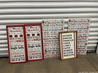 Five wooden Christmas signs with festive text and ornament decorations, displayed leaning against a shuttered background.