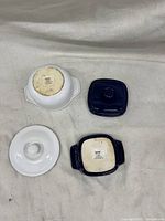 Two small casserole dishes with lids, viewed from bottom showing maker's marks