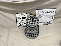 Photo showing galvanized 3-tier tray with checkered pattern, metal biscuit sign, and weekly menu sign with marker for scale and details.