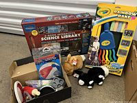 Full view of the lot showing the science kit box, Crayola Rainbow Rake, bunny plush toys, toy kitchen items in boxes