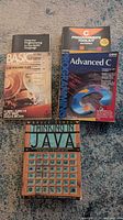 All five programming textbooks laid out on carpet