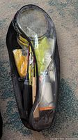 Badminton carry case showing six rackets, shuttlecocks, rope and accessories