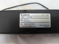Label showing Canon branding, model M111162, power specs