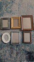 All six assorted small picture frames displayed on carpet