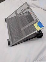 Side view showing mesh tray, tilt mechanism, black feet, yellow lot tag