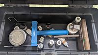 Toolbox interior showing paints, blue tool, paint can, file and tray