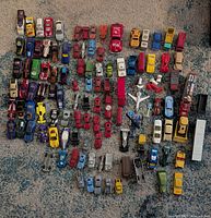 Full lot overview of roughly 100 assorted die-cast vehicles and accessories on rug