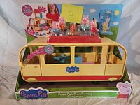 Front of boxed Peppa Pig Transforming Campervan playset showing camper, figures and package text