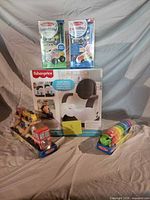 Group shot of boxed potty chair and four Melissa & Doug toys
