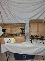 Both cartons opened showing two cast iron hook racks inside