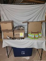 Overall view with sealed boxes, open carton of bagged figures, loose figures and four boxed sets