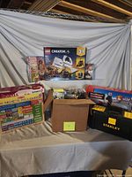 Overall lot showing LEGO set, calendar, games, toolbox, carton of LEGO pieces