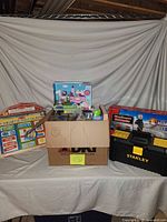 Overall lot showing magnetic calendar, box of toys, Stanley toolbox