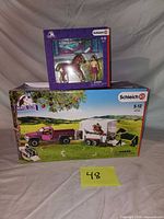Front view of both boxed Schleich sets with lot number card visible