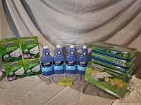 Group shot of all boxed cloths, wet pad packs, and cleaner bottles