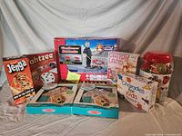 Group shot of all boxed games, craft kits, Little Tikes set and block jar