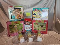 All items grouped: two giant floor puzzles, Play-Doh 10-packs, Play-Doh dentist set, magnet kit, bead jar
