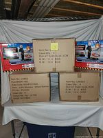 Stack of three shipping cartons with retail box image of toy wheelbarrow visible