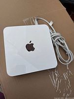 Top view of Apple Time Capsule showing white square unit with Apple logo and attached power cord.