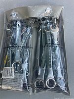 Set of 18 assorted combination wrenches visible through clear plastic packaging, showing various SAE and metric sizes.
