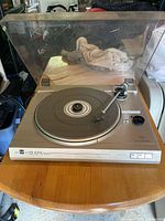 Front angled view of the Dual CS 616 Q turntable with dust cover closed showing the platter and tonearm on a wooden table.
