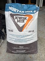 Front side of an unopened blue and brown Kwik Mix Mortar Mix 30lb bag showing brand, weight, and product use details.