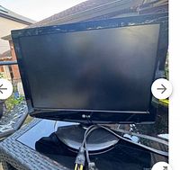 Front view of LG 19-inch monitor with black screen and circular stand, power cord visible in front.