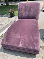 Front angle view of the oversized purple chaise lounge showing the wide seat and upright backrest.