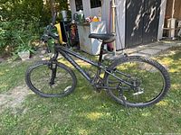 Side view of black Trek 820 mountain bike on grass showing frame, tires, saddle, and handlebars.