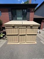 Front view of painted wooden bin shed with three front doors and two top lids