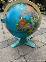 Front angle view showing Africa and Europe on the globe, turquoise plastic base and light-colored meridian with Fisher Price branding.