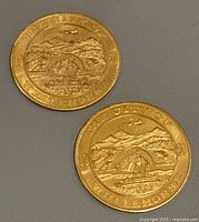 Obverse side of two Klondike Dollar coins showing The City of Whitehorse design with horse head sculpture and mountainous landscape, dated 1970.