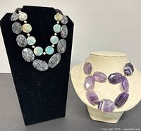 Three vintage gemstone necklaces displayed on black and beige busts, showing the variety of stones and necklace lengths.