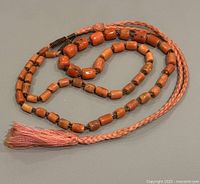 Full layout of the coral bead necklace showing the overall string and tassel.