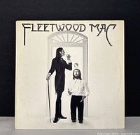 Front cover of Fleetwood Mac self-titled album showing two men, one tall and smoking, the other shorter, against a light background featuring the band name at the top.
