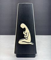 Front view of trapezoidal Søholm vase showing black ribbed side with raised cream-colored mother and child design.