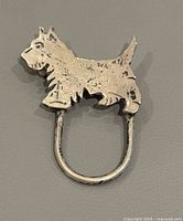 Top view of silver Scottish Terrier brooch showing dog shape and metal condition