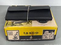 Close-up of black leather wallet style case for drafting set resting on microscope kit box