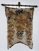 Full front view of tapestry hanging from brass rod