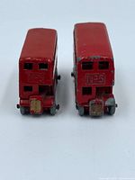 Rear view of both buses showing cast "No 5" detail and wheel condition