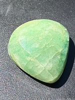 Front view of green pear-shaped emerald cabochon